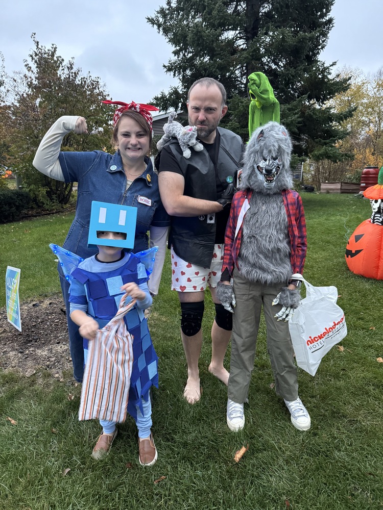My family all together at Halloween (Rosie the Riveter, an Allay from Minecraft, Carl from Dungeon Crawler Carl, and a werewolf)